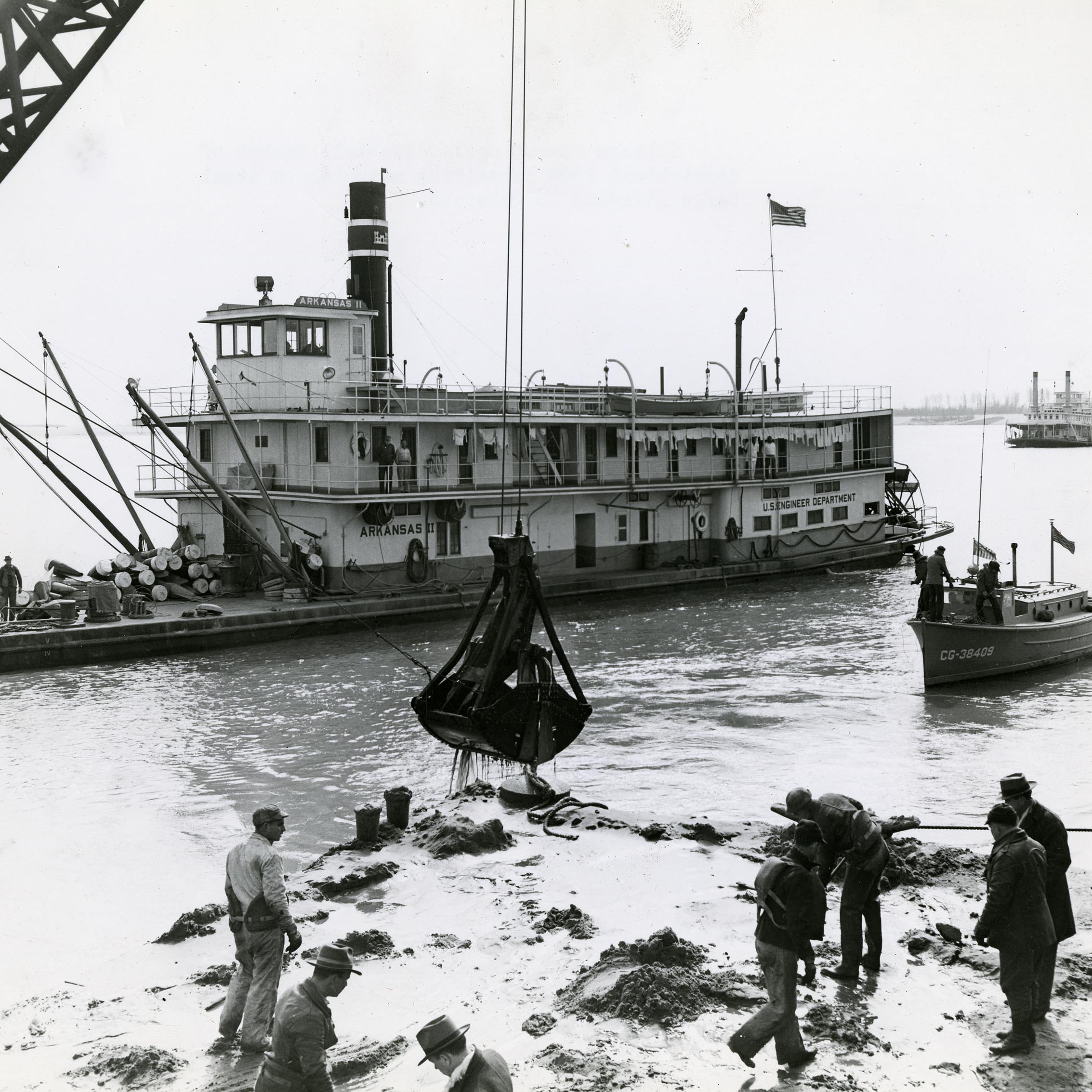 Large boat with crane deposits wreckage onto a barge